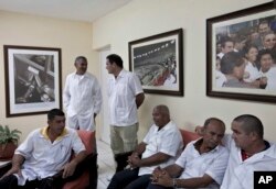 FILE - These Cuban doctors, waiting for the start of a press conference in Havana, were among 91 health workers who traveled to Liberia and Guinea to help with treatment of Ebola patients, Oct. 21, 2014.