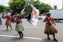 Aksi unjuk rasa mahasiswa Papua untuk kemerdekaan provinsi Papua, di markas polisi di Surabaya, 1 Desember 2021, bertepatan dengan hari jadi Gerakan Papua Merdeka (OPM). (Juni KRISWANTO / AFP)