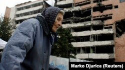 Arhiva - Žena prolazi ispred nekadašnje zgrada Generalštaba Vojske Srbije u Beogradu, koja je srušena u NATO bombardovanju 1999, u Beogradu, 24. marta 2000.