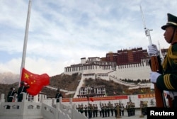 拉萨布达拉宫前面举行升旗典礼，中国武警有人持枪，有人敬礼。（2010年3月28日）