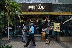 Orang-orang berjalan melewati gerai Burgreens, jaringan restoran nabati, di Serpong, Tangerang Selatan, 23 September 2021. (Foto: REUTERS/Willy Kurniawan)