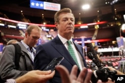 FILE - Paul Manafort talks to reporters on the floor of the Republican National Convention at Quicken Loans Arena in Cleveland, July 17, 2016.