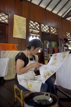 Turis Jepang Machiko Momoya mengoleskan lilin cair ke tekstil katun halus untuk menghasilkan desain figuratif pada kursus membatik di Museum Tekstil, Jakarta, pada 17 Maret 2012. (Foto: AFP/Oscar Siagian)