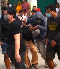 Polisi menangkap tersangka militan di luar rumah di Bekasi, Jawa Barat, 13 Oktober 2019. (Foto: AFP/Reza)