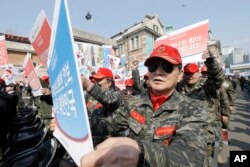 South Korean war veterans hold up their placards during a rally denouncing North Korea's recent threats in Seoul, South Korea, March 25, 2016.