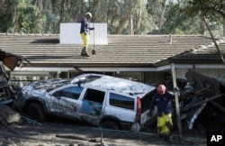 Emergency crew members search an area damaged by storms in Montecito, Calif., Jan. 12, 2018.