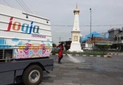 Petugas dari BPBD DIY melakukan penyemprotan desinfektan di kawasan Tugu, 22 Maret 2020. (Foto: Courtesy/Humas Pemda DIY)