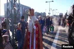 Anak-anak di Munich, Jerman, menerima kunjungan kejuta dari St. Nicholas sebelum mereka naik ke kereta api kuno untuk perjalanan spesial Natal bersamanya.