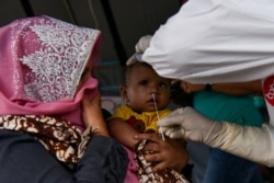 Seorang tenaga kesehatan mengambil sampel dengan tes usap COVID-19 di perbatasan Deli Serdang di tengah penerapan PPKM di Medan, Sumatra Utara, Sabtu, 10 Juli 2021. (Foto: Fransisco Carolio/Antara Foto via Reuters)