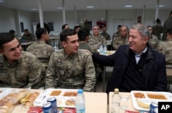 FILE - Hulusi Akar, Turkey's defense minister and former chief of staff, speaks with soldiers during a visit to Turkish troops stationed at the border with Syria, in Kilis, Turkey, Dec. 31, 2018. Russian and Turkish foreign and defense ministers met in Moscow two days earlier to discuss northern Syria as U.S. forces prepare to withdraw and Turkey threatens to launch a military operation against U.S.-backed Kurdish forces controlling nearly a third of the country.