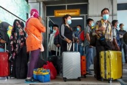 Para pekerja migran Indonesia yang tiba dari Malaysia di pelabuhan Bandar Sri Junjungan di Dumai, Riau, 2 April 2020. (Foto: AFP)