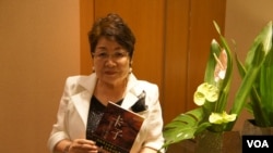 远藤誉接受美国之音采访时，展示早已被译成中文的《卡子》(美国之音歌篮拍摄)