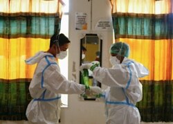 Para petugas kesehatan mengenakan alat pelindung diri (APD) bersiap menangani pasien COVID-19 di unit gawat darurat di Jakarta, 17 Juni 2021. (Foto: Ajeng Dinar Ulfiana/Reuters)