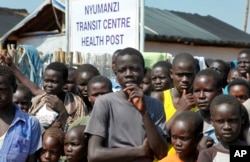 FILE - Refugees listen as U.N. High Commissioner for Refugees Filippo Grandi speaks during a visit to a transit center for South Sudanese refugees in the remote northwestern district of Adjumani, near the border with South Sudan, in Uganda, Aug. 29, 2016.