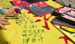 香港市民陳小姐五一勞動節在社民連街站留言支持在囚抗爭者及民主派人士。 (美國之音湯惠芸拍攝)