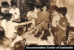 FILE - Chhang Song, assistant to Lon Nol’s spokesperson Am Rong who spoke in a press conference, stood to the right with a logo on his left sleeve. Chhang Song was later appointed Minister of Information of the Khmer Republic. The young men sitting in the front row are Viet Cong’s soldiers captured from the battle fields. (Documentation Center of Cambodia Archives/The Lon Nol Dossier)