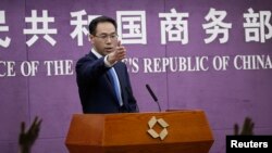 Chinese Ministry of Commerce spokesman Gao Feng gestures as journalists raise hands for questions during a press conference at the Ministry of Commerce in Beijing, April 6, 2018.