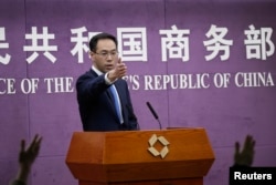 Chinese Ministry of Commerce spokesman Gao Feng gestures as journalists raise hands for questions during a press conference at the Ministry of Commerce in Beijing, April 6, 2018.