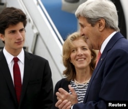 U.S. Ambassador to Japan Caroline Kennedy, center, and her son Jack Schlossberg, left, greet Secretary of State John Kerry as he arrives, ahead of G-7 foreign minister meetings, at Marine Corps Air Station Iwakuni, Japan, April 10, 2016.