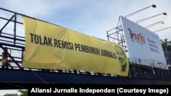 Pemasangan spanduk raksasa menuntut pencabutan remisi pembunuh jurnalis di jembatan penyeberangan depan kantor Jawa Pos di Surabaya, 9 Februari 2019. (Foto: Aliansi Jurnalis Independen)