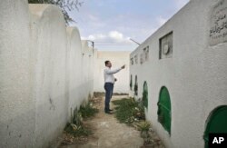 Dalam foto 5 November 2014, Reda el-Danbouki, pengacara Sohair el-Batea, 13 tahun, yang meninggal setelah menjalani sunat perempuan yang dilakukan oleh Dr. Raslan Fadl, menunjukkan makamnya di Desa Dierb Biqtaris, Mesir.