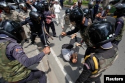 រូបឯកសារ៖ បុរស​ម្នាក់​ត្រូវបាន​សន្តិសុខ​ខណ្ឌ​៧មករា វាយ​នឹង​ដំបង​ដែក នៅ​ក្នុង​អំឡុង​ពេល​ដែល​លោក​ចូលរួម​ដង្ហែ​ក្បួន​ប្រារព្ធ​ទិវា​ពលកម្ម​អន្តរជាតិ រាជធានី​ភ្នំពេញ កាលពី​ថ្ងៃទី១ ខែ​ឧសភា ឆ្នាំ២០១៤។ (Reuters)