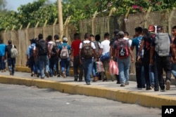 FILE - Central American migrants cross into Mexico from Guatemala, near Ciudad Hidalgo, Mexico, June 4, 2019.