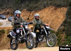 Presiden RI Joko Widodo (kiri) didampingi Panglima TNI Gatot Nurmantyo mengendarai sepeda motor saat mengunjungi jalan Trans Papua, 7 kilometer antara Wamena - Habemam, di Jayawijaya pada 2017. (Foto: Antar/Indrianto Eko Suwarso via REUTERS)