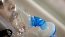 ARHIVA - Čovek diše kroz masku sa kiseonikom u bolnici u Bukureštu (Foto: AP)