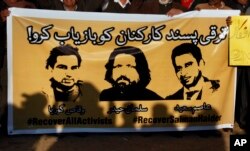 FILE - Members of civil society hold a banner with pictures of missing rights activists, Waqas Goraya, Salman Haider, and Asim Saeed, during a demonstration to condemn the missing human rights activists, in Islamabad, Pakistan, Jan. 10, 2017.
