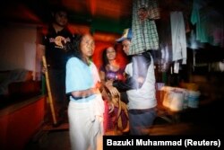 Petugas imigrasi Malaysia menahan dua perempuann yang diduga pekerja migran ilegal dari Indonesia dalam sebuah operasi di Nilai, di luar Kuala Lumpur. (Foto: Reuters/ Bazuki Muhammad)