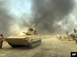 Iraqi Security Forces enter Qayara, 70 kilometers (45 miles) south of Mosul, after defeating Islamic State group forces in northern Iraq, Aug. 25, 2016.