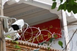 Spanduk propaganda dan kamera pengamanan dipasang di masjid tua di Kota Tua di Kashgar, Wilayah Autonomi Xinjiang Uighur, China, 6 September 2018.