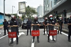 Light Strike Force team from the Royal Malaysian Police (LSF) stand at attention during a rally of 'Arrest Azam Baki' in Kuala Lumpur on Jan. 22, 2022.
