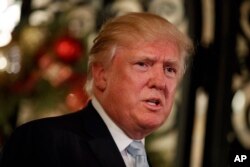 FILE - President-elect Donald Trump speaks to reporters at Mar-a-Lago.