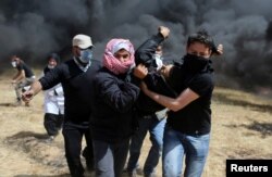 A wounded Palestinian demonstrator is evacuated during clashes with Israeli troops at the Israel-Gaza border at a protest demanding the right to return to their homeland, in the southern Gaza Strip, April 6, 2018.