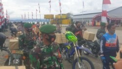 Personel TNI-POLRI menggunakan sepeda motor mendistribusikan bingkisan bantuan sosial untuk masyarakat Poso Pesisir, Kabupaten Poso, Sulawesi Tengah. Rabu (23/12/2020). (Foto: VOA/Yoanes Litha)