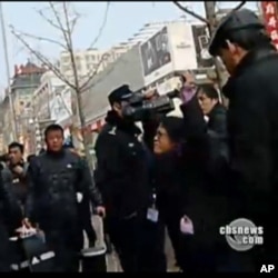 何宗安高举双手抗议被警察推挤的镜头(照片中右侧带眼镜的女记者)