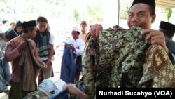 Para pengungsi memilih pakaian pantas pakai sumbangan para donatur.