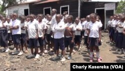 Des écoliers en fil devant une salle de classe à Goma, le 23 septembre 2015. (VOA/Charly Kasereka)