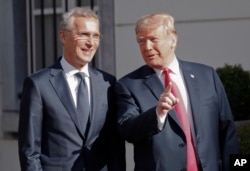 FILE - U.S. President Donald Trump, right, gestures as he speaks to the media prior to his bilateral breakfast with NATO Secretary-General Jens Stoltenberg, left, in Brussels, Belgium, July 11, 2018.
