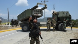 一名菲律宾士兵在参加美菲联合军演后在高机动性多管火箭系统(HIMARS) 前用手机自拍。(2016年4月14日)