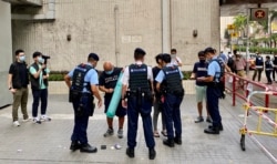 大批全副装备的军装警员在社民连十一游行起点，花了十几分钟搜查参与游行的4名社民连成员 (美国之音/汤惠芸)