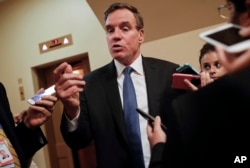 FILE - Sen. Mark Warner, D-Va., speaks with reporters on Capitol Hill in Washington, Sept. 27, 2017.