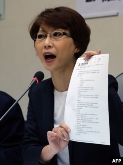 台湾民进党立法委员陈亭妃在立法院向媒体展示台湾与中国大陆签署的一项司法协议文版. (2016年4月12日)