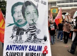 Para pengunjuk rasa menampilkan spanduk yang memperlihatkan Sjamsul Nursalim (kiri) dan Anthony Salim (kanan) - dua orang terkaya di Indonesia yang dituduh menggelapkan jutaan dolar melalui BLBI selama krisis Asia pada 1998, Jakarta, 22 Juli 2008. (Foto: