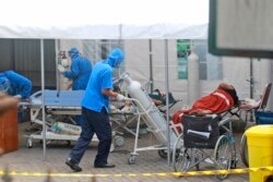 Seorang petugas medis mendorong tangki oksigen yang akan digunakan untuk merawat pasien di tenda darurat yang didirikan untuk menampung lonjakan kasus COVID-19, di RSUP Dr Sardjito Yogyakarta, Minggu, 4 Juli 2021. (AP Photo/Kalandra)