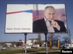 FILE - A billboard with a portrait of Russian President Vladimir Putin is displayed on a street in Kerch, Crimea, April 7, 2016. The board reads: "Crimea. Russia. Forever."