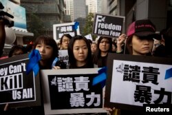 FILE - Staff members of Ming Pao newspaper take part in the march against violence on journalists in Hong Kong, March 2, 2014.