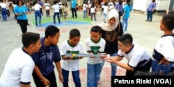 Siswa-siswi dari Madrasah Ibtidaiyah (MI) Islamiyyah-Plosogenuk, SD Kristen Petra, SD Katolik Wijana, dan sejumlah anak SD anggota jemaat GKJW Bongsorejo, bermain bersama sambil menanti waktu berbuka puasa (Foto:VOA/Petrus Riski).